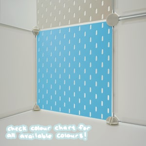 May include: A bright blue square pegboard panel featuring a repeating pattern of vertical slots. The panel is framed by white plastic connectors and corner pieces. Text at the bottom reads: check colour chart for all available colours!