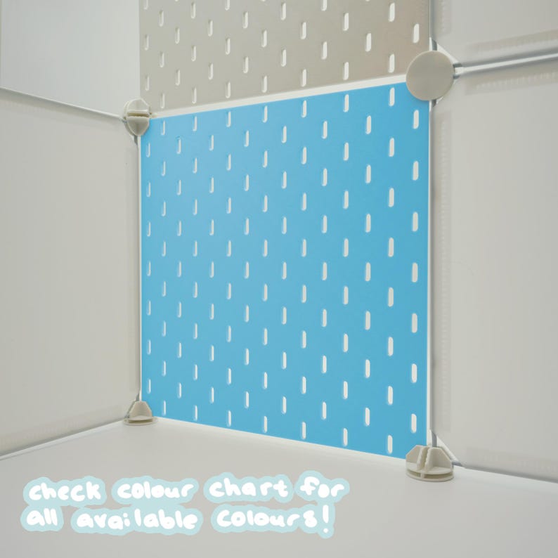 May include: A bright blue square pegboard panel featuring a repeating pattern of vertical slots. The panel is framed by white plastic connectors and corner pieces. Text at the bottom reads: check colour chart for all available colours!