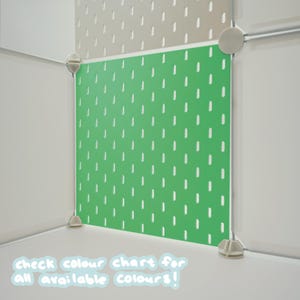 May include: A bright green pegboard panel featuring a repeating pattern of vertical slots, secured within a modular white frame system. The text "check colour chart for all available colours!" is printed in white at the bottom of the image.