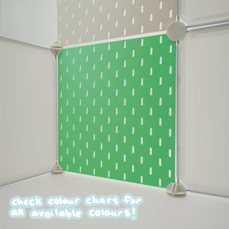 May include: A bright green pegboard panel featuring a repeating pattern of vertical slots, secured within a modular white frame system. The text "check colour chart for all available colours!" is printed in white at the bottom of the image.