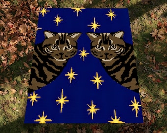 May include: A blue square blanket featuring two brown tabby cat faces and yellow star patterns. The blanket has a digital representation disclaimer in the bottom right corner.