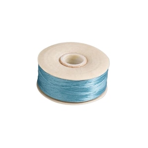May include: A spool of light blue thread wound around a circular cardboard core. The thread has a smooth, slightly reflective texture and is wrapped evenly around the center of the spool, leaving the top and bottom edges of the cardboard exposed.