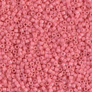 May include: A close-up shot displays a dense collection of small, cylindrical beads in a soft, pastel pink hue. Each bead has a hole running through its center. The beads are scattered, creating a textured surface, ideal for crafting and jewelry making.