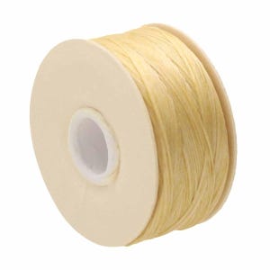 May include: A spool of light yellow, textured cord wrapped around a circular cardboard core. The cord has a fibrous, natural appearance with visible strands wound tightly in a continuous layer around the center of the spool.
