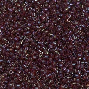 May include: Close-up of a pile of small, cylindrical beads in shades of burgundy and purple. The beads have a metallic sheen and are densely packed together, creating a textured surface. These beads are suitable for jewelry making and crafts.