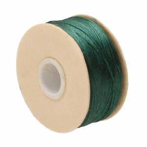 May include: A spool of dark green thread wound tightly around a circular cardboard core. The thread has a smooth, slightly glossy texture and is wrapped in multiple layers, creating a thick, uniform cylinder of deep forest green colored cord.