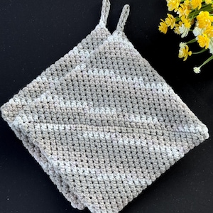 Puede incluir: Dos agarraderas cuadradas hechas a mano con ganchillo, en tonos grises y blancos. Cada agarradera tiene un lazo para colgar. Las agarraderas están hechas con un patrón de puntada texturizada y son adecuadas para la cocina.