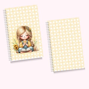 Puede incluir: Dos cuadernos con espiral. Uno presenta una niña de dibujos animados con los ojos cerrados, una camisa amarilla y un peto azul, leyendo un libro. La portada tiene un patrón de cuadros amarillos con corazones blancos. El segundo cuaderno tiene el mismo patrón de cuadros amarillos.