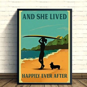 Peut inclure: Affiche encadrée avec le texte « AND SHE LIVED HAPPILY EVER AFTER ». L'image présente une silhouette d'une personne portant une planche de surf sur une plage avec un chien. L'arrière-plan montre l'océan, les montagnes et un ciel bleu.