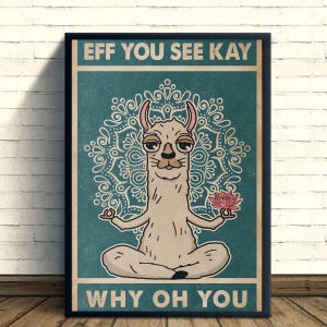 以下が含まれることがあります： ヨガのポーズをとる漫画のラマが描かれた額入りのポスター。ピンクの蓮の花を持っています。ポスターには、白いマンダラのデザインが施された、ターコイズ色の背景に白い文字で「EFF YOU SEE KAY WHY OH YOU」と書かれています。