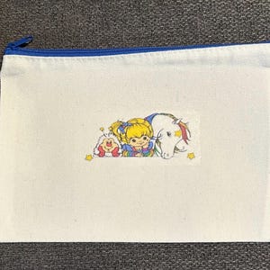 Rainbow Brite, Sprite, and Starlite on a Rainbow pouch.  Perfect size for a pencil pouch or makeup pouch.