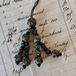 Gorgeous Art Deco 1920s antique metallic gold tassel with blue bead accent