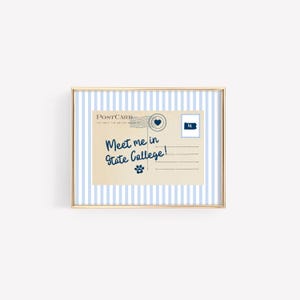 May include: A framed postcard with a gold border. The postcard has a blue and white striped background. The postcard reads "Meet me in State College!" in blue script. A paw print and a postage stamp are also visible.