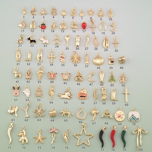 May include: A collection of eighty gold-toned metal charms featuring various shapes including stars, animals, food items, symbols, and flowers. Each charm is numbered from one to eighty, displayed in a grid layout with small jump rings at the top.