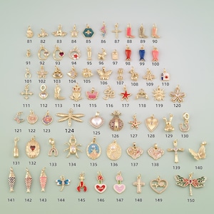 May include: A collection of gold-tone metal charms in various shapes including animals, hearts, flowers, crosses, and insects. Each charm is numbered from 81 to 150, featuring enamel details, rhinestones, and metallic finishes for jewelry making.