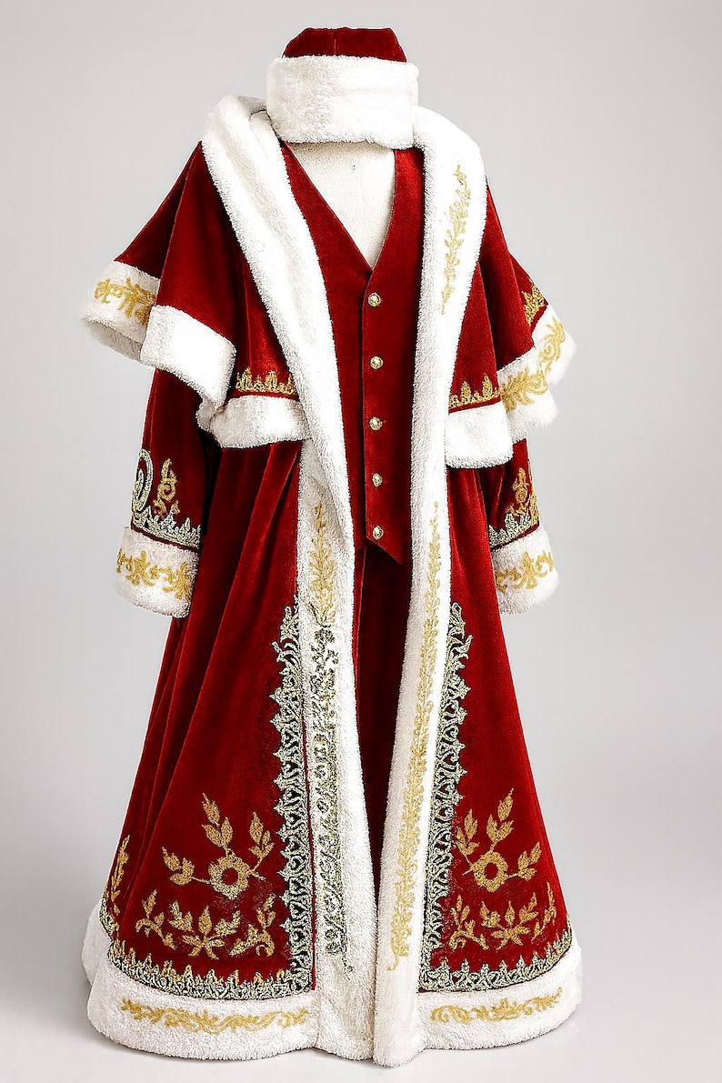 May include: A festive red velvet costume with white faux fur trim and gold embroidery. The ensemble includes a long coat, vest, and hat. The coat features ornate gold leaf and scroll designs, perfect for a holiday or theatrical event.