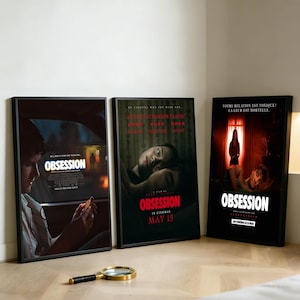 Puede incluir: Tres carteles de películas enmarcados con el título "Obsesión". Los carteles tienen fondos oscuros con imágenes de personas. Una lupa con borde dorado y mango negro descansa en el suelo frente a los carteles.