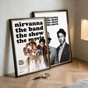 May include: Two framed movie posters with the text "nirvanna the band the show the movie." The posters feature images of actors and the text "ONE... LAST... PLAN." A gold magnifying glass rests in front of the posters.