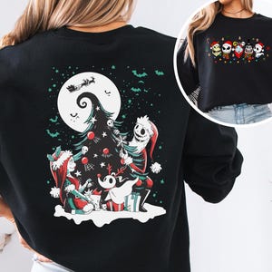 K&ouml;nnte beinhalten: Schwarzes Sweatshirt mit einem festlichen Aufdruck mit Figuren aus The Nightmare Before Christmas. Das Design umfasst Jack Skellington, Sally, Zero und einen Weihnachtsbaum. Das Sweatshirt hat einen Rundhalsausschnitt und lange &Auml;rmel.