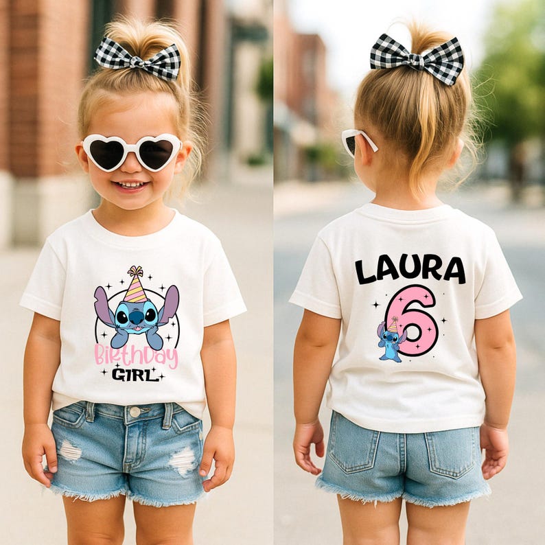K&ouml;nnte beinhalten: Wei&szlig;es T-Shirt mit einem Aufdruck eines blauen Cartoon-Charakters mit Partyhut und dem Text "Birthday Girl". Auf der R&uuml;ckseite des Shirts stehen der Name "Laura" und die Zahl "6". Das M&auml;dchen tr&auml;gt Jeansshorts und eine schwarz-wei&szlig;e Schleife.