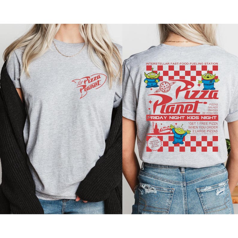 May include: A gray t-shirt featuring the Pizza Planet logo in red on the front and back. The back of the shirt has a larger Pizza Planet design with alien characters, text, and a checkered pattern. The shirt promotes "Friday Night Kids Night."