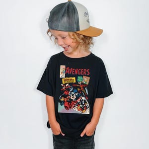 May include: A white ceramic mug with a black handle and the text "But First, Coffee" in a handwritten style. The mug is on a white surface. The mug is approximately 4 inches tall.