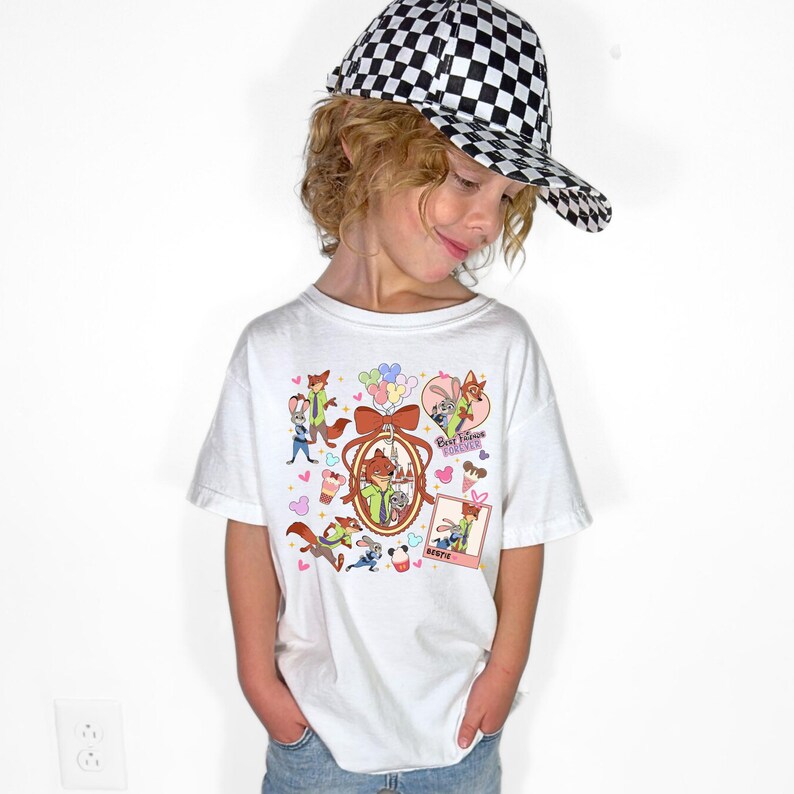 Może przedstawiać: Biała koszulka z postaciami z kresk&oacute;wek i napisem "Best Friends Forever". Koszulka ma okrągły dekolt i kr&oacute;tkie rękawy. Osoba na zdjęciu ma na sobie czarno-białą czapkę z daszkiem w szachownicę.