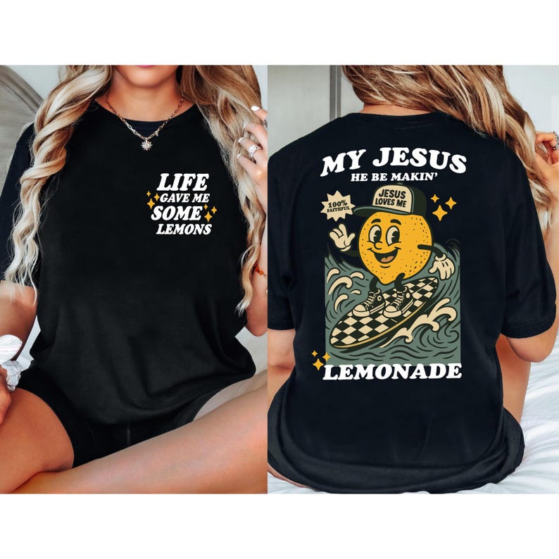 Puede incluir: Camiseta negra con el texto "LIFE GAVE ME SOME LEMONS" en la parte delantera. La parte trasera de la camiseta presenta un lim&oacute;n de dibujos animados surfeando en una tabla de surf a cuadros con el texto "MY JESUS HE BE MAKIN' LEMONADE".