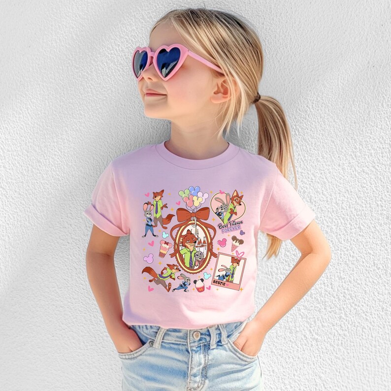 Może przedstawiać: Jasnor&oacute;żowa koszulka z kolorową grafiką postaci z kresk&oacute;wek, balon&oacute;w i napisem "Best Friends Forever". Koszulka jest noszona przez młodą osobę w r&oacute;żowych okularach przeciwsłonecznych w kształcie serca.