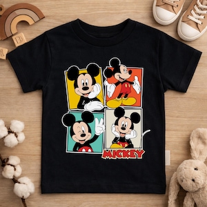 May include: Black short-sleeved t-shirt featuring a four-panel design of Mickey Mouse in various poses. Each panel has a different colored background. The word "MICKEY" is printed in red and white at the bottom.