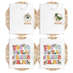 May include: Four white t-shirts with colorful graphics. Two shirts feature cartoon characters with the word "NAME" below. The other two shirts display the text "YOU'VE GOT A FRIEND IN ME" in a colorful, playful font.
