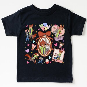 Może przedstawiać: Granatowa koszulka z motywem z filmu Zwierzogr&oacute;d. Projekt przedstawia Nicka Wilde'a i Judy Hopps, wraz z napisami "Best Friends Forever" i "Bestie". Projekt zawiera r&oacute;wnież serca, rożki lod&oacute;w i balony.