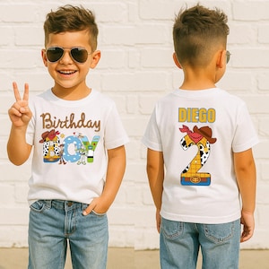 May include: White t-shirt with "Birthday BOY" text and a cartoon cowboy design. The back of the shirt has the name "DIEGO" and a number "2" with a cowboy hat and bandana design. The boy is wearing blue jeans and sunglasses.