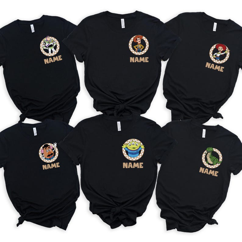 May include: Six black t-shirts featuring characters from a popular animated movie. Each shirt has a circular design with a character image and the word "NAME" below. The characters include Buzz Lightyear, Woody, Jessie, Mr. Potato Head, an alien, and Rex.