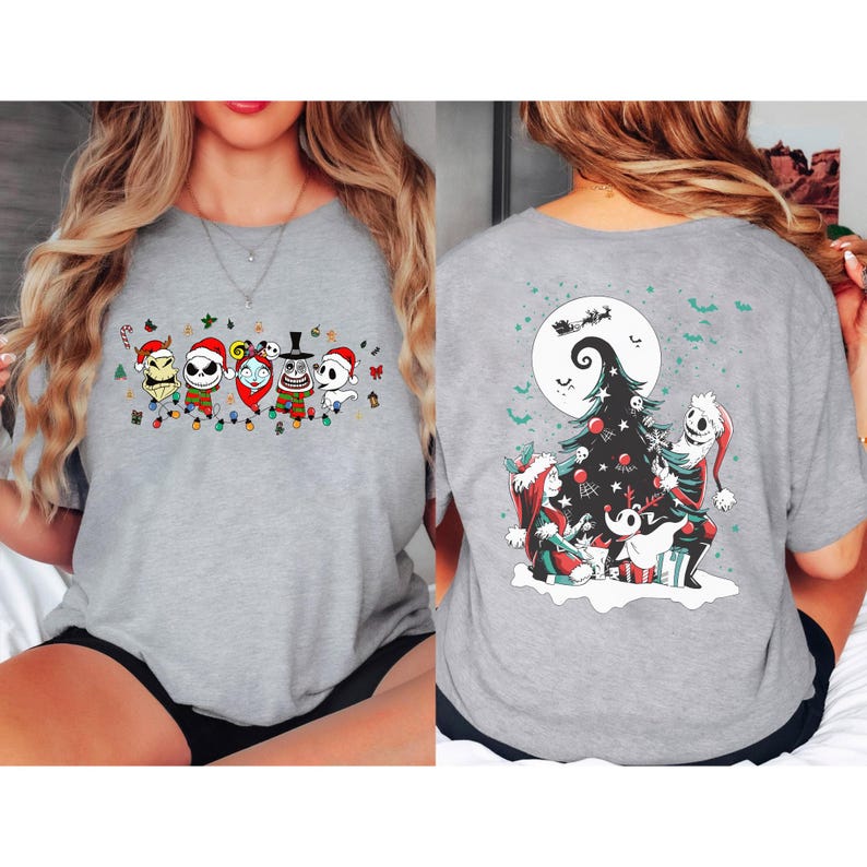 K&ouml;nnte beinhalten: Graues T-Shirt mit einem festlichen Aufdruck von Charakteren aus The Nightmare Before Christmas, jeder mit einem Weihnachtsmannhut. Auf der R&uuml;ckseite des Shirts ist ein Weihnachtsbaum mit Jack Skellington und anderen Charakteren abgebildet.