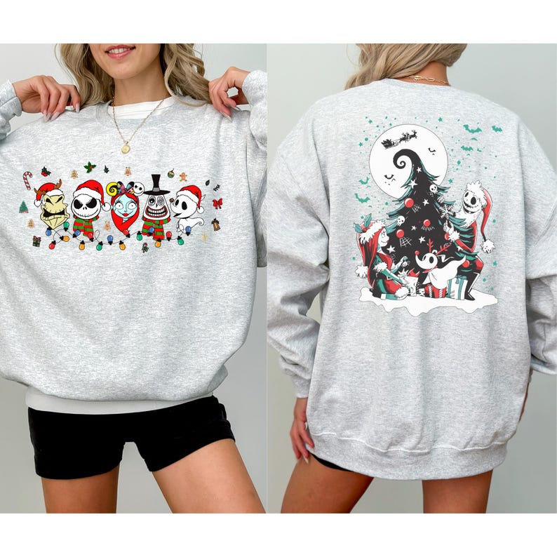 K&ouml;nnte beinhalten: Ein hellgraues Sweatshirt mit einem festlichen Design aus einem beliebten Animationsfilm. Auf der Vorderseite sind Charaktere mit Weihnachtsm&uuml;tzen und einer Lichterkette zu sehen. Auf der R&uuml;ckseite ist ein Weihnachtsbaum mit Charakteren und einem Vollmond abgebildet.