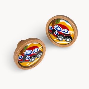 May include: Two wooden cabinet knobs with a colorful car design. The knobs have a light brown wooden frame and a circular image of a red car with blue windows, black tires, and a yellow background.