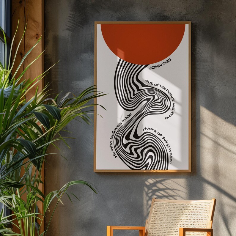 May include: A framed vertical wall art print featuring a large burnt orange semi-circle at the top and a central black and white wavy, distorted line pattern. The text reads: JOHN 7:38, He who believes in Me out of his heart will flow rivers of living water.