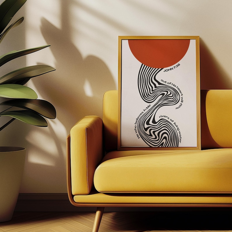 May include: A framed vertical wall art print featuring a solid red circle at the top and a black and white wavy, distorted line pattern flowing downwards. The text reads: "He who believes in Me out of his heart will flow rivers of living water" and "JOHN 7:38".