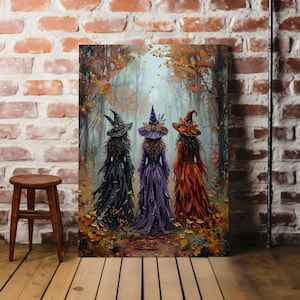 May include: A rectangular wall art print depicting three figures wearing pointed hats and long, flowing dresses in black, purple, and orange, standing in a forest filled with autumn leaves. The scene features a misty, wooded background with trees.