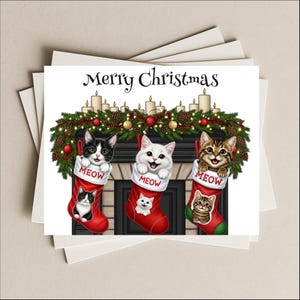 May include: A Christmas card featuring three adorable kittens peeking out of red stockings. The stockings are labeled "MEOW" and hang above a fireplace decorated with a festive garland and candles. The words "Merry Christmas" are written at the top.