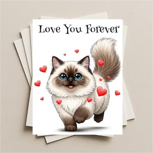 May include: A greeting card with the text "Love You Forever" features a cartoon cat with blue eyes, brown markings, and a fluffy tail. Red hearts are scattered around the cat. The card is white and is stacked with other cards.
