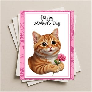 May include: A Mother's Day greeting card featuring a cartoon orange tabby cat holding a pink rose. The card has a pink border with floral accents and the text "Happy Mother's Day" in black script. The card is on a stack of white cards.