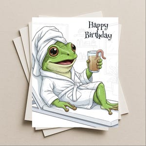 May include: A greeting card featuring a cartoon frog in a spa setting. The green frog wears a white robe and towel, holding a drink with a worm garnish. The card reads "Happy Birthday" in black script.
