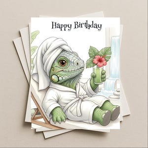 May include: A stack of greeting cards featuring a cartoon iguana in a spa setting. The iguana is wearing a white robe and towel, holding a green drink with a red flower. The card reads "Happy Birthday".