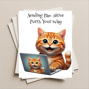 May include: A greeting card featuring a cartoon orange tabby cat with blue eyes, smiling and using a laptop. The card has the text "Sending Paw-sitive Purrs Your way". The laptop screen shows a smaller version of the cat.