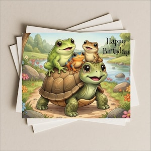 May include: A greeting card featuring a cartoon illustration of a turtle carrying three frogs. The frogs are green, orange, and brown. The card has the words "Happy Birthday" written on it. The background shows a river and trees.