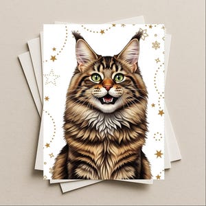 May include: A stack of greeting cards featuring a detailed illustration of a Maine Coon cat with green eyes and a smiling expression. The cat has brown and tan fur. Gold stars and dots decorate the white background.