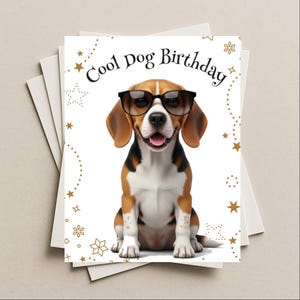 May include: A stack of white greeting cards with a "Cool Dog Birthday" design. The card features a cartoon beagle wearing glasses. Gold stars and snowflake accents frame the image.