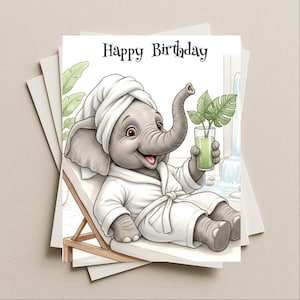 May include: A birthday card featuring a cartoon elephant relaxing in a spa setting. The elephant wears a white robe and towel, holding a green drink. The words "Happy Birthday" are printed at the top.